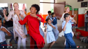 children and student-athletes dancing in a classroom