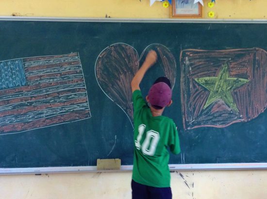 Student drawing a heart on a chalk board