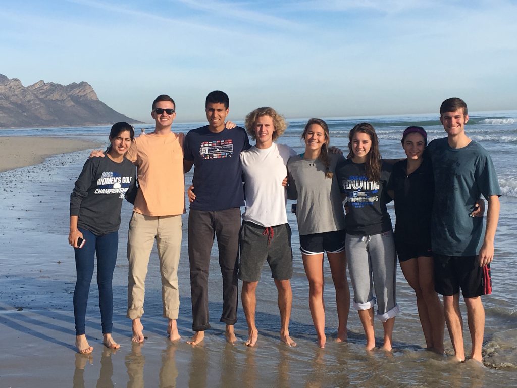 A group of student-athletes posing together on the beach