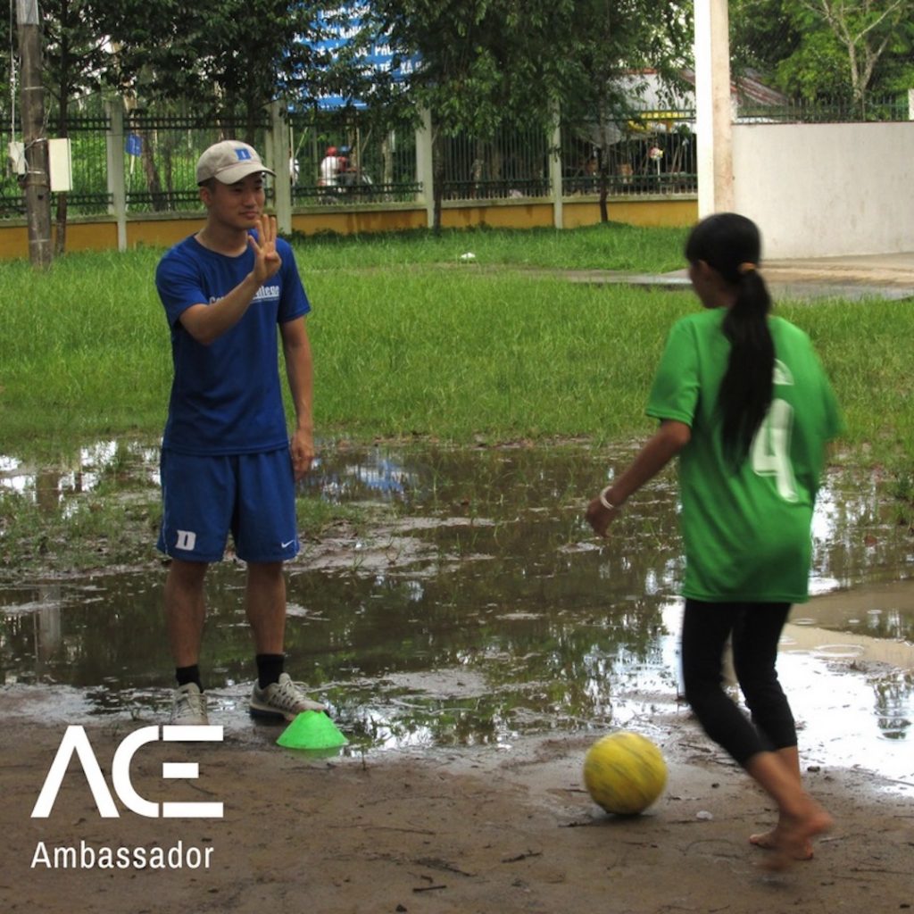 ACE participant playing soccer with child