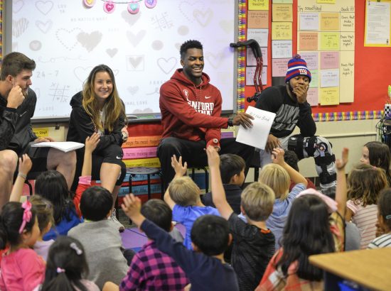 Students reading to children in classroom