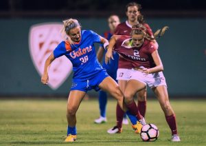 two women diving for soccer ball on field