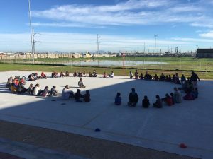 kids gathered in a circle playing duck duck goose