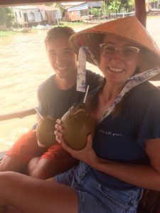 Students smiling holding coconuts