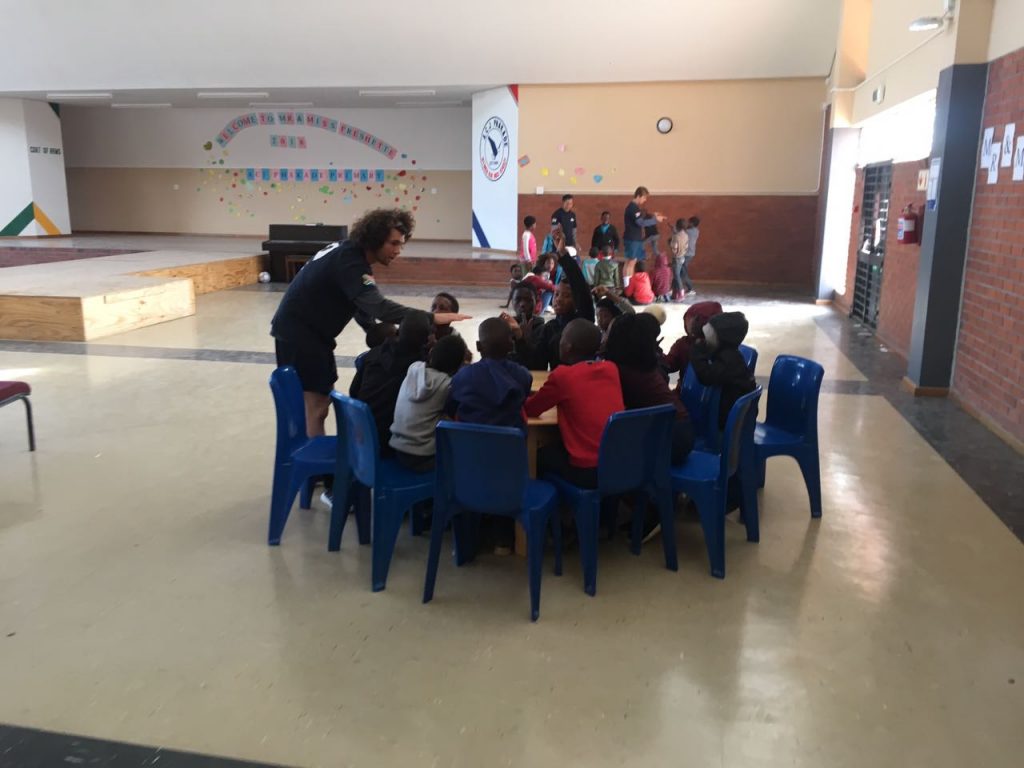 Teacher talking to students sitting at a table