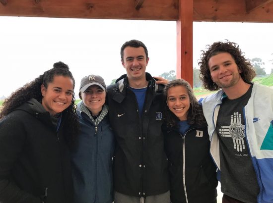 Group of Duke ACE athletes smiling in raincoats