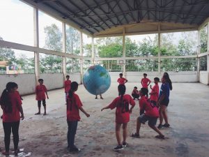 Students playing volleyball with giant globe