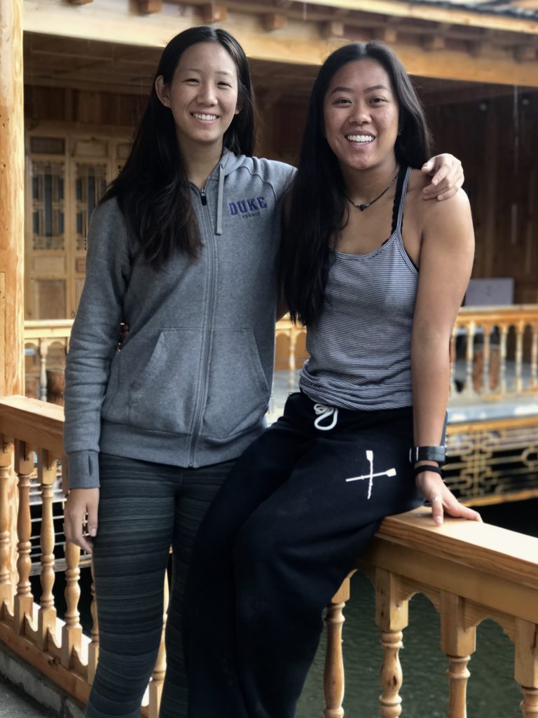 two students smiling with arms around each other