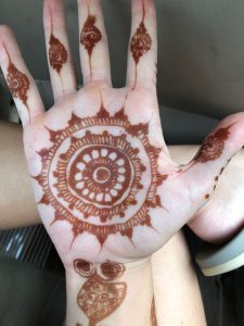 hand with brown henna art design