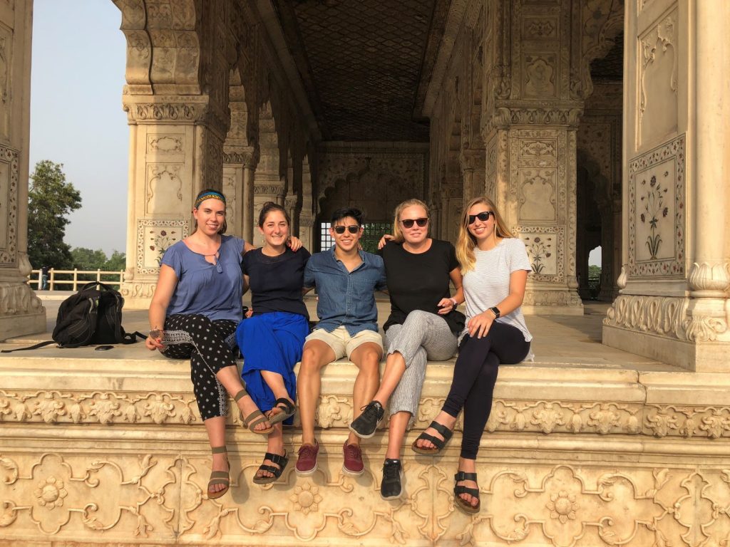 five students sitting with arms around each other