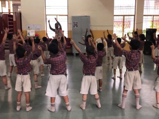 children dancing together with arms in the air