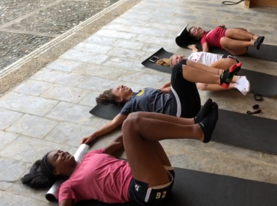four students working out on mats on the floor
