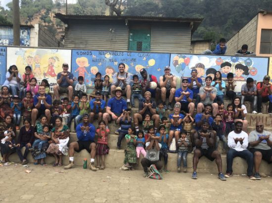 group of athletes and children posing for group photo
