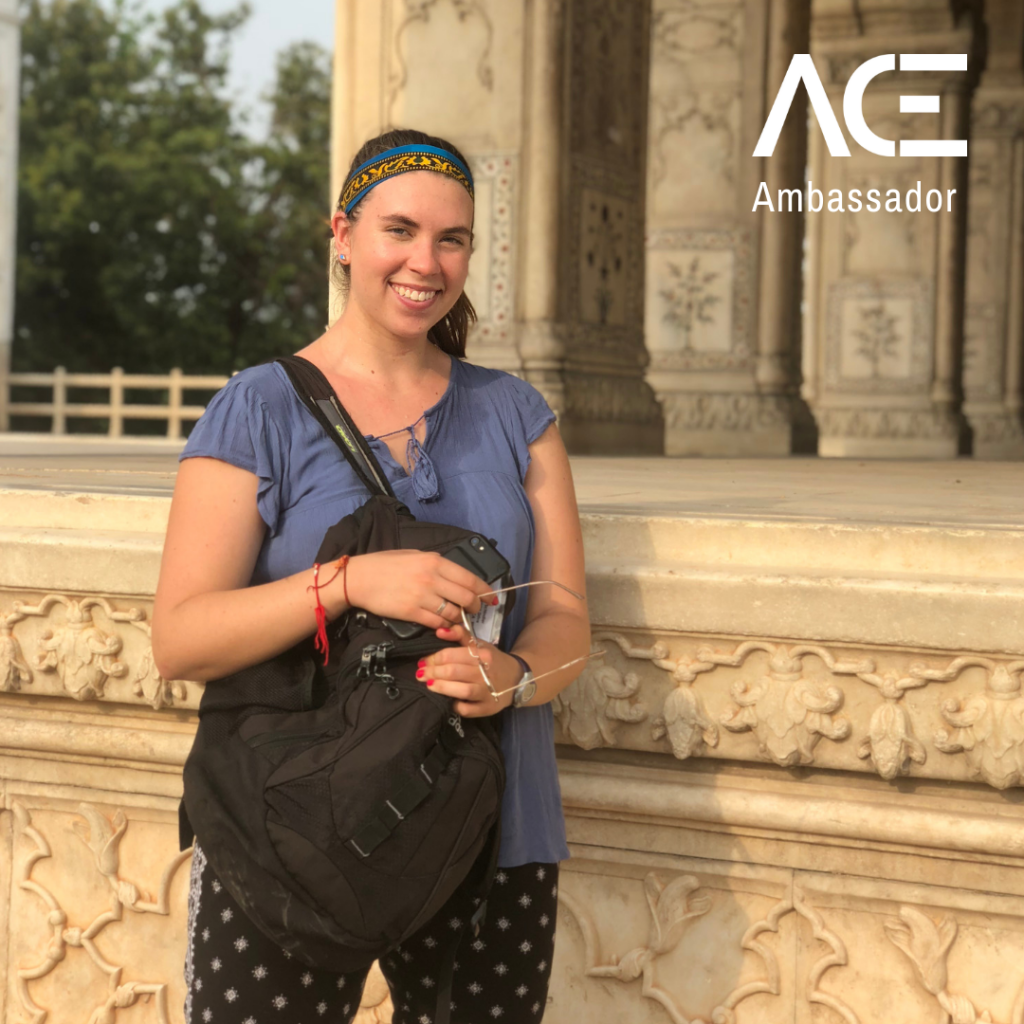 female standing in front of columns outside