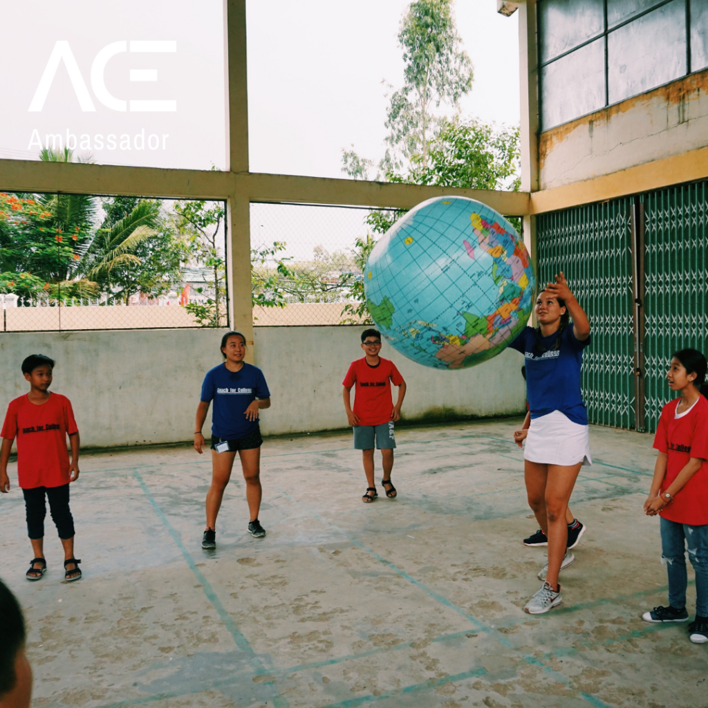 young adult throwing globe in circle with kids