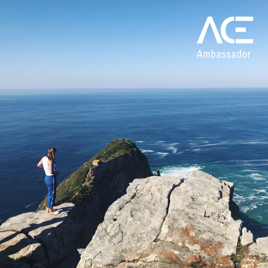 woman standing on rock overlooking ocean