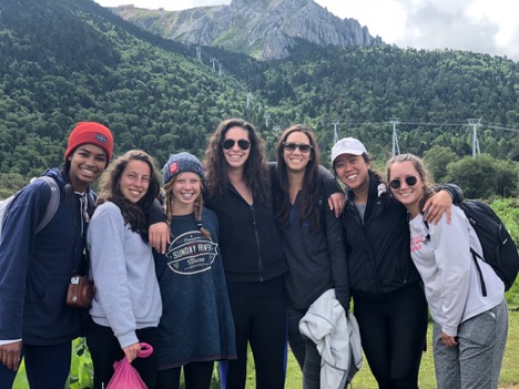 group of women standing together in front of mountain