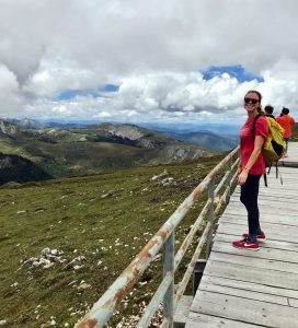 female standing on bridge by mountain overlook