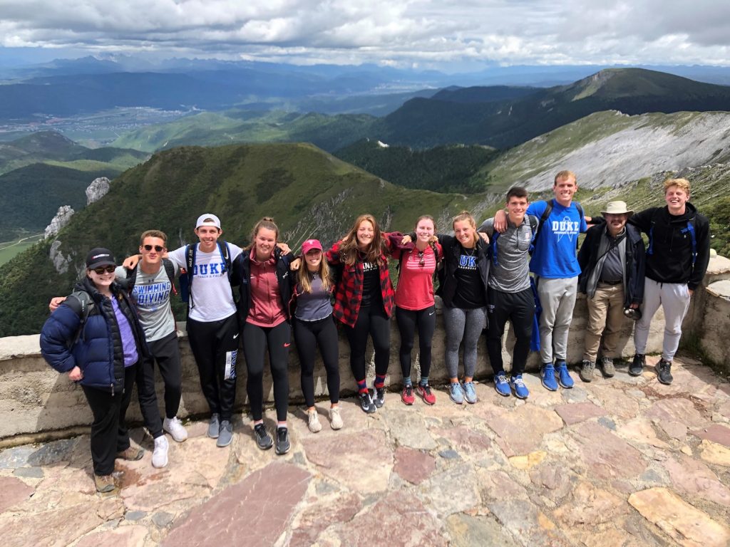 group posing above mountainous overlook