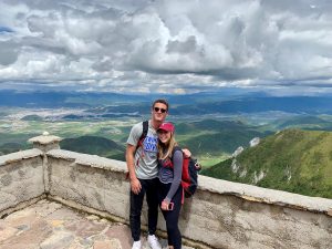 two people posing in front of mountainous overlook