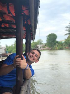 young adult male holding onto pole of water boat