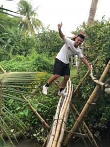 male young adult balancing on bamoo straws