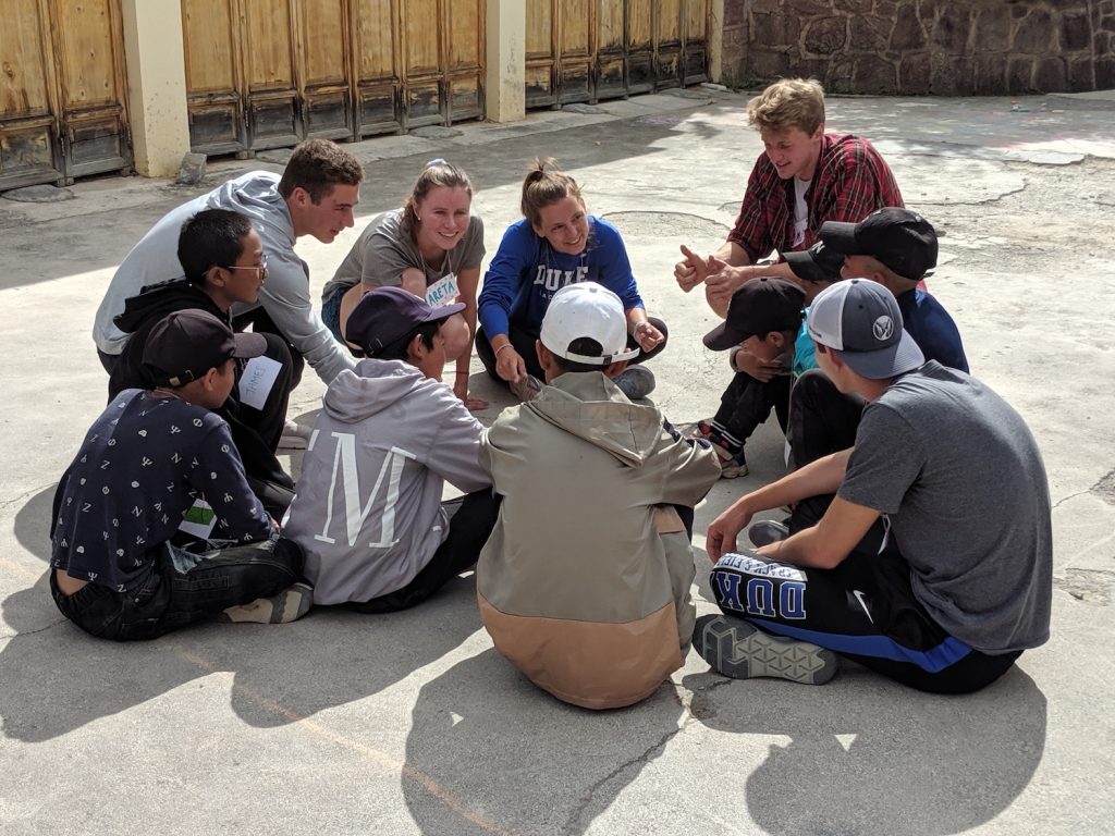 group sitting outside huddling on basketball court