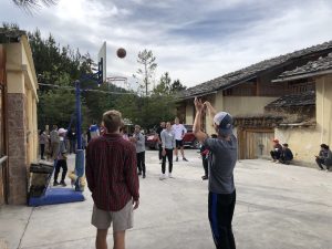 person shooting basketball outside