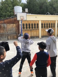 group of children shooting basketball outside