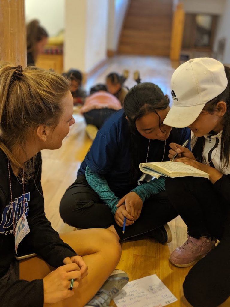 young adult teaching to child in classroom