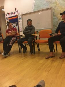 three men talking in front of classroom