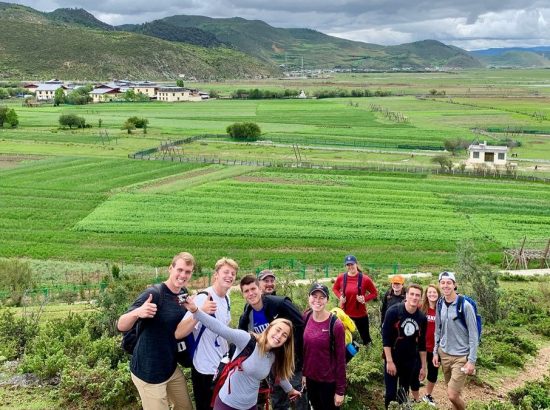 group phoyo in front of green fields and mountains