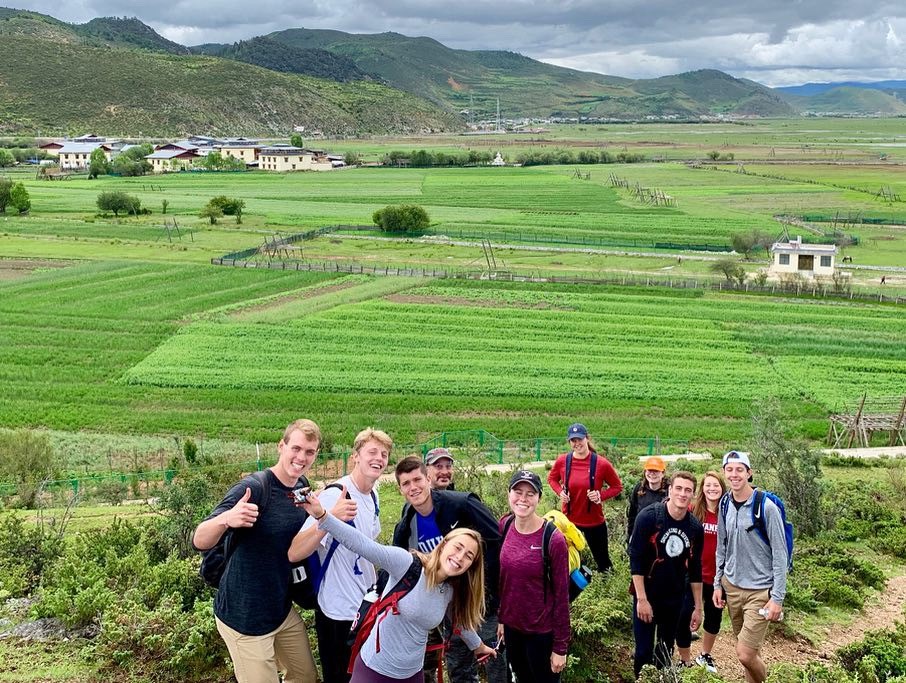group phoyo in front of green fields and mountains