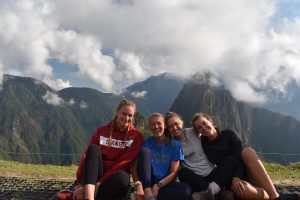 group of women smiling in front of mountains