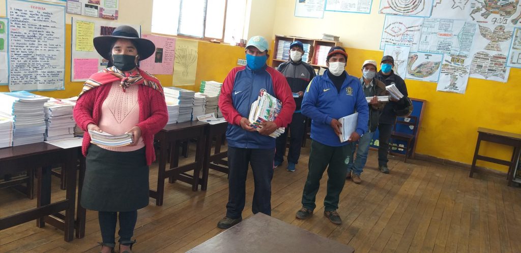 group of people wearing masks in line holding books