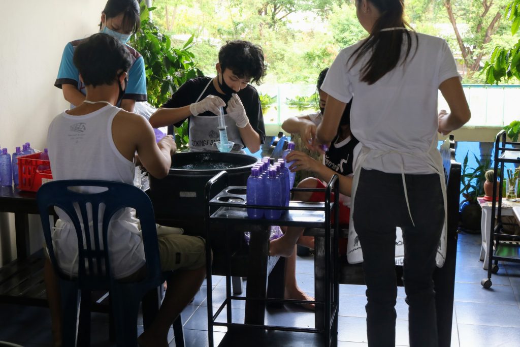 group of students using syringes to pour liquid into tubes