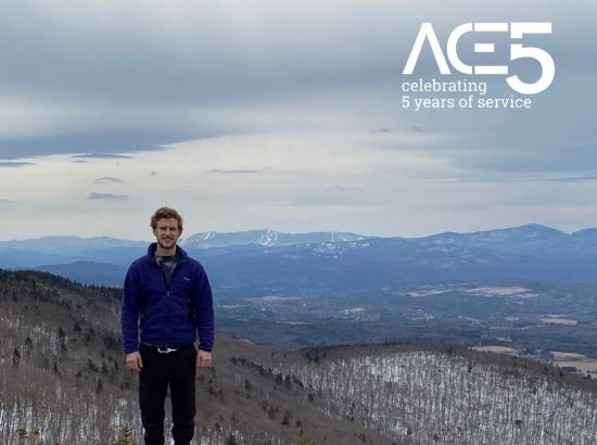 man standing in front of snowy mountainous overlook