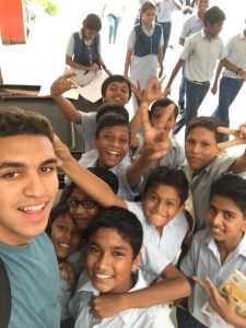 young man smiling with schoolchildren