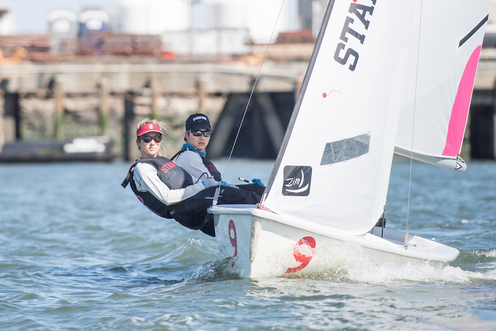 woman and man leaning back in sailboat