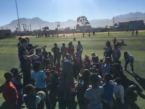 group of students and children outside playing rugby