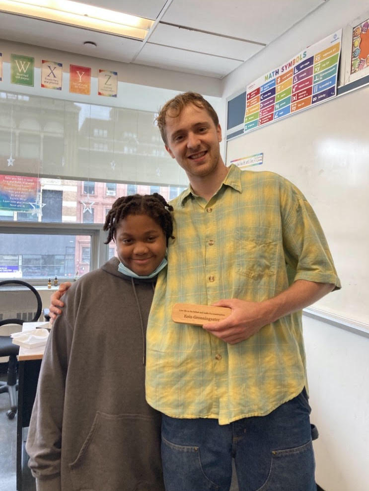 teacher smiling with student in classroom