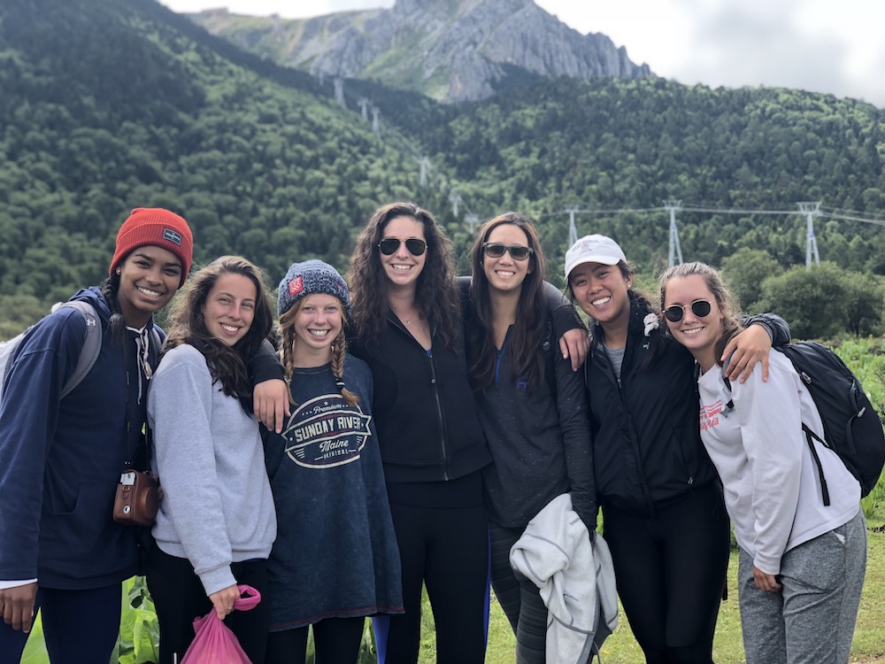 group of women smiling in front of mountain