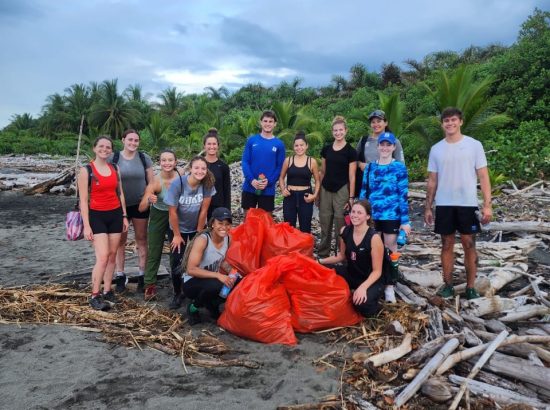 students on beach with collected trash