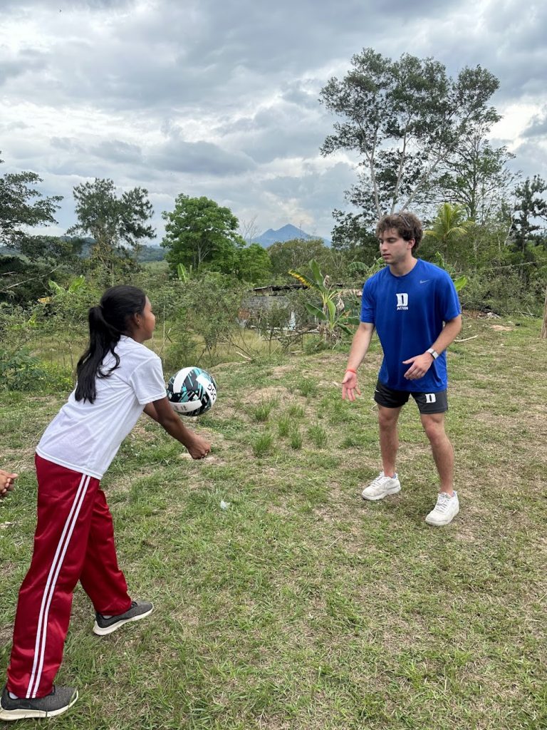 student playing volleyball with youth